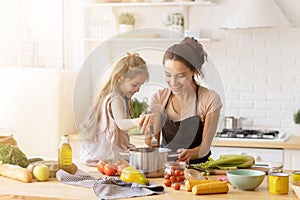 Mommy teaching lovely kid to cook.