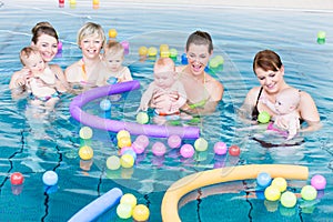 Moms and babies playing at infant swimming class