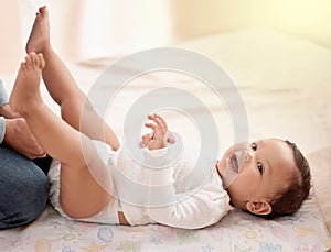 Moms on diaper check duty. a woman changing her adorable baby girls diaper at home.