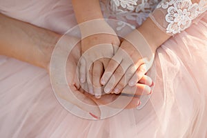 Moms hand holds in her palm the hands of her little daughter