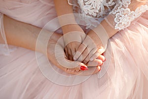 Moms hand holds in her palm the hands of her little daughter