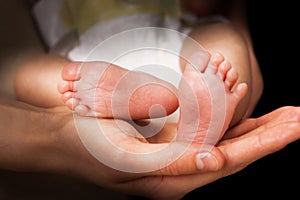 Moms hands holding baby's feet