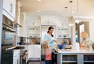 Moms lucky to have two handy little helpers. a mother baking cookies with her two little kids at home.