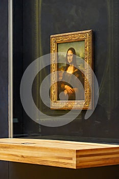 The Mona Lisa original painting on display in the Louvre Museum. The Mona Lisa is a half-length portrait painting by Italian artis