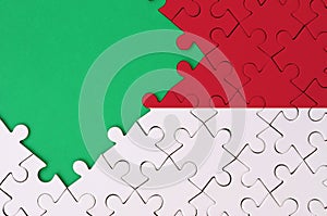 Monaco flag is depicted on a completed jigsaw puzzle with free green copy space on the left side
