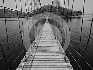 Monchrome rope bridge direct to lonely island across the lake