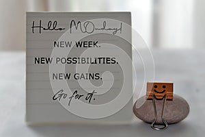 Monday concept with text message on notepaper - Hello Monday. New week. New possibilities. New gains. Go for it. photo