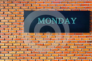 Monday letters on a black background with brick wall