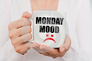 Monday mood with sad symbol on white coffee cup