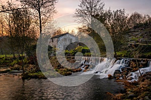 Mondim de Basto waterfall with a mill house at sunset in Portugal