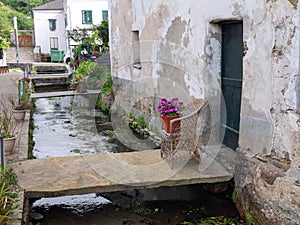 MONDONEDO, SPAIN - AUGUST 08, 2021:Stone bridge in front of the building entrance in the old neighborhood of mills and craftsmen