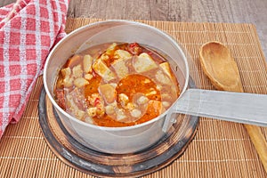Mondongo a la espanola or cayos a la espanola. Presented in a saucepan on a wooden table View at 45 degrees photo