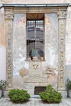 MONDOVI, ITALY - AUGUST 16, 2016: Ancient facade with columns, bas relief and capital in summer in Mondovi, Italy