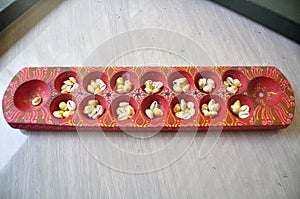 Monetaria moneta shells or Money cowry shell in wooden red tray for malaysian people and foreign travelers select and buy made photo