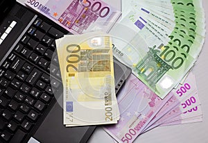 Money against laptop euro against notebook