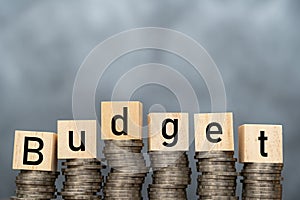 Money annual budget concept. stacked coins and wooden cubes with word Budget on coins background