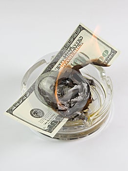 Money in an ashtray burns