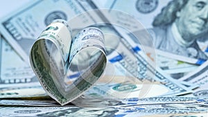 One hundred dollars US banknote in the shape of a heart. Money background. Concept financial love and a gift for Valentine`s Day.