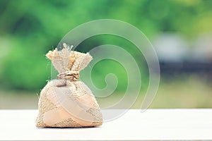 Money bag attached to the plaster on natural green background,Saving money for Medical expenses and Health care concept