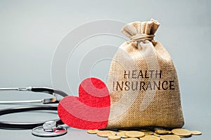 Money bag with coins and the inscription Health Insurance and a heart with a stethoscope. The concept of medical insurance of life