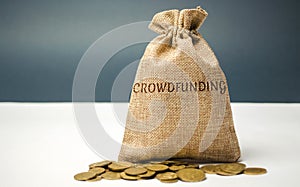 Money bag with coins with the word crowdfunding. Voluntary association of money or resources via the Internet. Support recipients