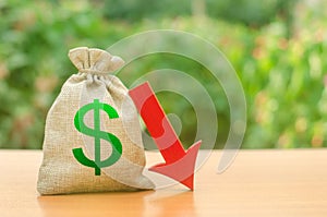 Money bag with dollar symbol and red arrow down. Reduced profits and liquidity of investments. Reduced tax revenues photo