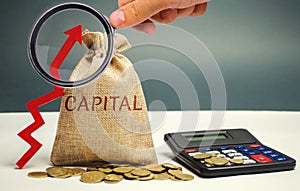 Money bag with the word Capital and an up arrow. The concept of accumulation and increase in money capital. Increase in capital