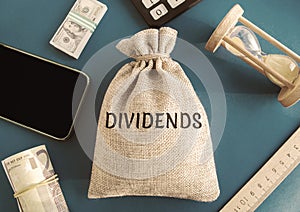 Money bag with the word Dividends. Payment made by a corporation to its shareholders as a distribution of profits. Concept photo