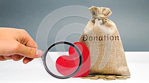 A money bag with the word Donation and a red heart. Accumulation of money for a medical donation. Health care. Saving. Social