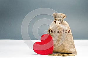 A money bag with the word Donation and a red heart. Accumulation of money for a medical donation. Health care. Saving. Social photo