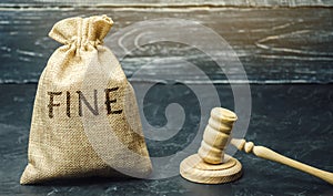 Money bag with the word Fine and the judge`s hammer. Penalty as a punishment for a crime and offense. Financial punishment.