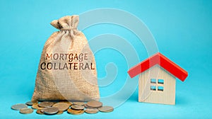 Money bag with the word Mortgage collateral and wooden house. Affordable housing programs for young families. Governmental support