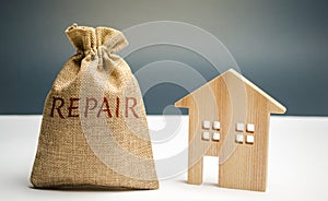 Money bag with the word repair and a wooden house. Saving and accumulation of money to repair. Concept of a new house, apartment