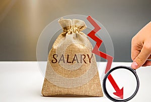 Money bag with the word Salary and arrow to down. lower salary, wage rates. demotion, career decline. lowering the standard of photo