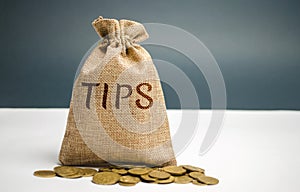 Money bag with the word Tips. Award for good service in the cafe / restaurant. A gratuity is a sum of money customarily given by a photo