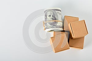 Money banknotes and cardboard boxes isolated on a white background. Online package transportation concept