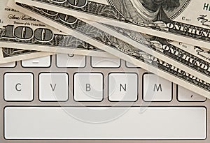 Money bills on computer keyboard with spacebar photo