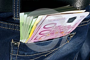 Money in blue jeans pocket.