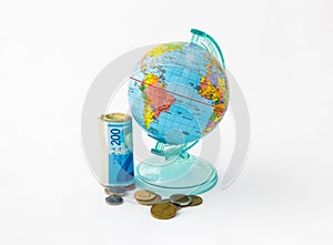 A money box made in the form of a globe, the planet Earth with a money slot at the top stands near a rolled up and held together s