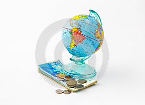 A money box made in the form of a globe, the planet Earth with a money slot at the top stands on a stack of Israeli banknotes of d