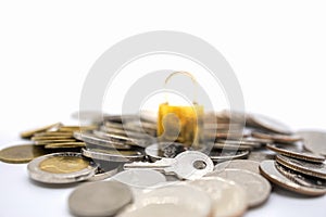 Money, Business and Security Concept.  Close up of silver key on pile of coins with master key lock on white background and copy