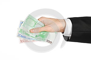 Money and business topic: hand in a black suit holding banknotes 10,20 and 100 euro on white isolated background in studio