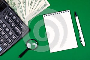 Money, calculator and notebook on green background