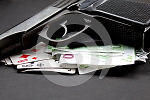 Money cards and gun on black background