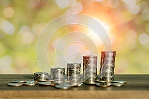 Money coin stack growing graph with abstract bokeh in the morning background
