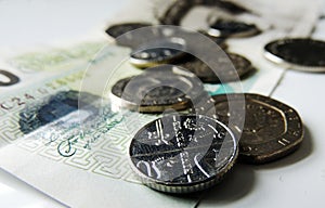 Money - coins and a banknote, with focus on the 5 pence coin