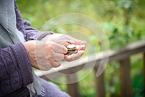 Money, coins, the grandmother on pensions and a concept of a living minimum - in hands of the old woman isn`t enough money photo