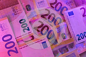 Money colored background. Two hundred euro in purple neon light.Euro exchange rate in the European Union. Money and