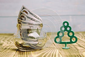 Money concept, transparent glass with dollar banknote on a wooden table. tree is a profit symbol, there is toning. shallow depth