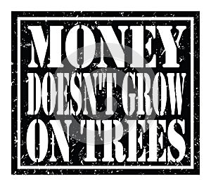 MONEY DOESN`T GROW ON TREES, text written on black stamp sign photo